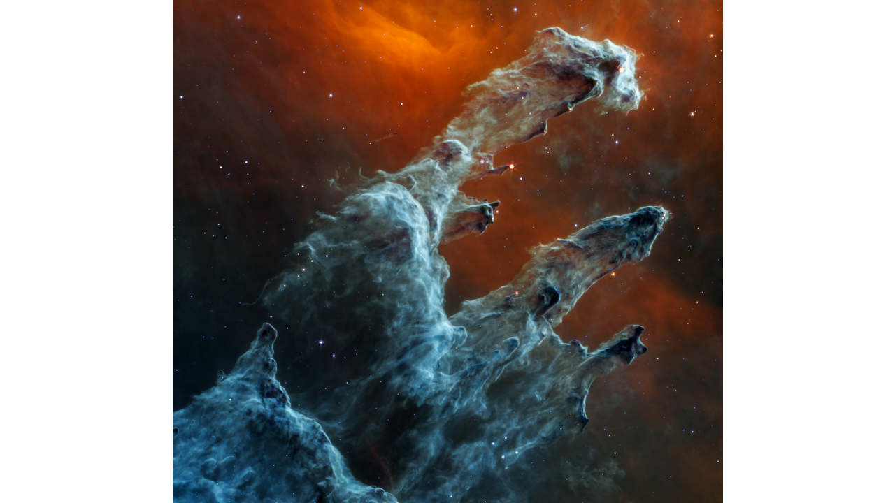 Many layers and pillars of semi-opaque gas and dust overlay one another. These regions appear light blue and dark gray-blue. The first pillar starts at the bottom left and extends to the top right. There is one prominent red star, with tiny spikes at its tip. Lower on this pillar, there are several darker areas of dust that jut out, many with bright red stars that appear as small red dots at their ends. Below the top pillar are two slightly smaller pillars, both ending in dark gray-blue regions. The second pillar has a dark arch that looks like an upside-down L halfway down. The background of this scene is washed in shades of red. Toward the top center is a V shape. At its lowest point, the V is a brilliant red. There are only several dozen tiny bright white and blue stars in this overall scene. Larger stars appear redder and are embedded in the pillars - from Webbtelescope.org