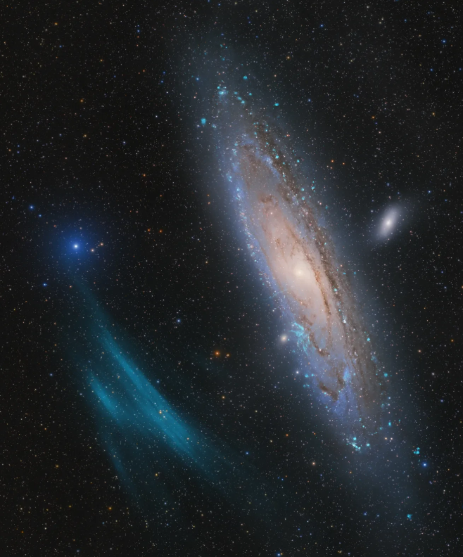 To the right of the image is positioned the spiral galaxy of Andromeda, shown in swirling pastel pinks toward its center which fade out to a diffuse violet and blue glow. To the left of Andromeda is a blue ethereal plasma arc, looking as though someone has dragged a partially-coated blue paintbrush against the dark background dotted with innumerable blue, orange, red, and white stars.